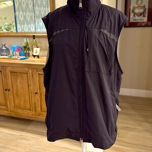 100% polyesterter. Pull cord on bottom of vest to tighten the fit. Lightweight